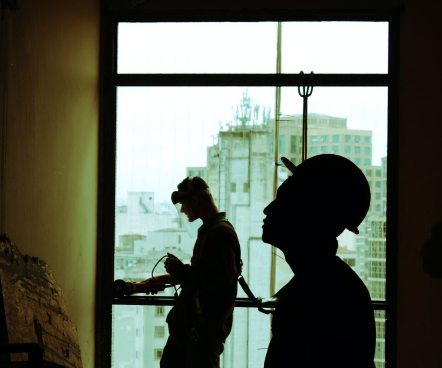 two men wearing hard hat standing near clear glass window