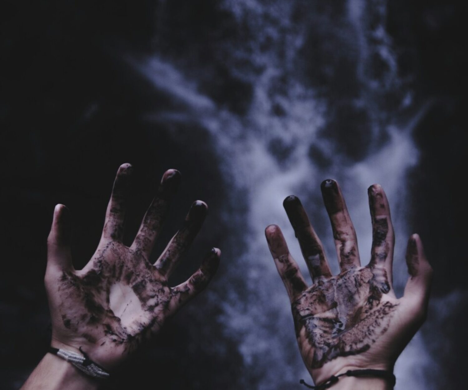 person hands with black liquids