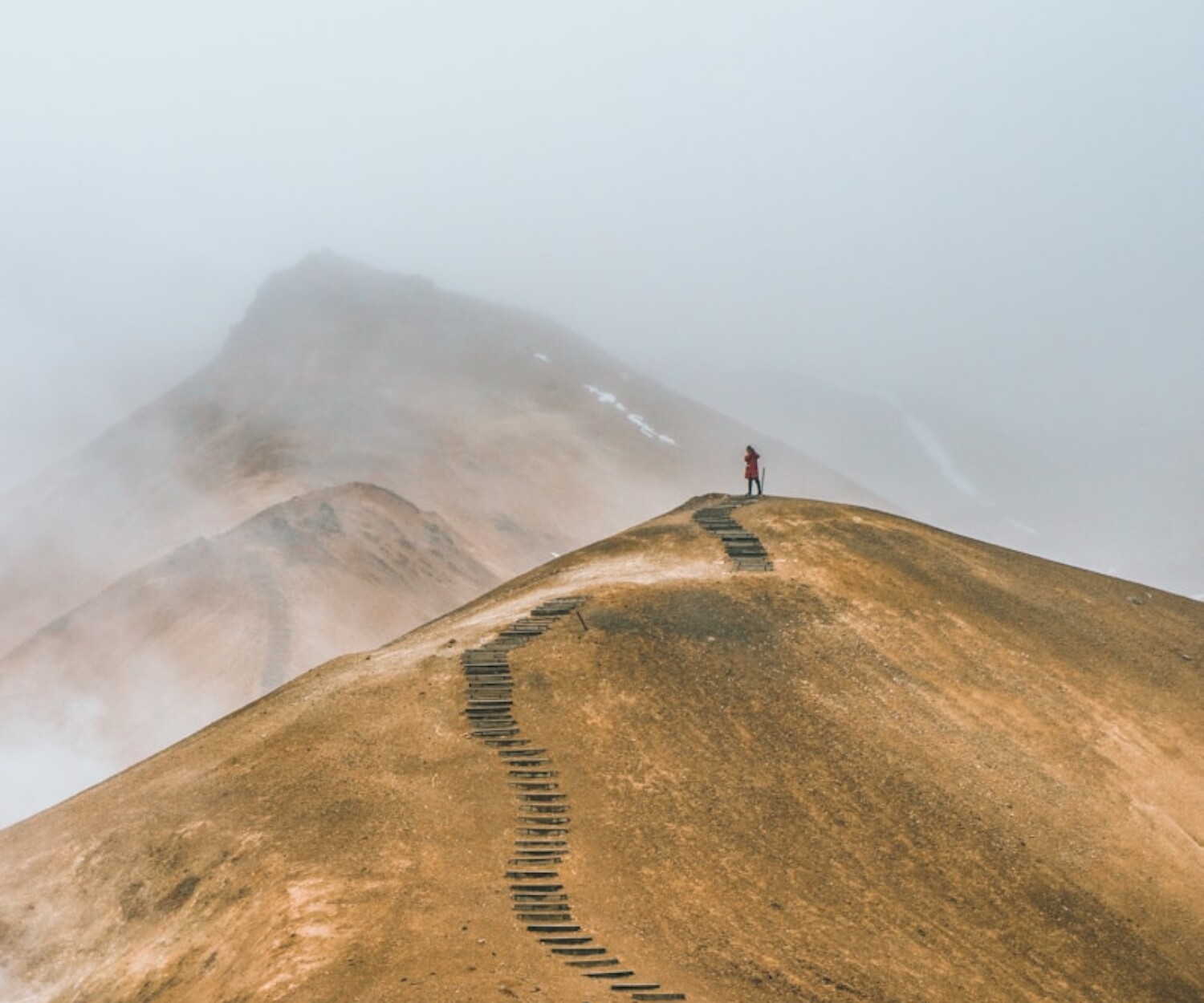 man on top brown hill