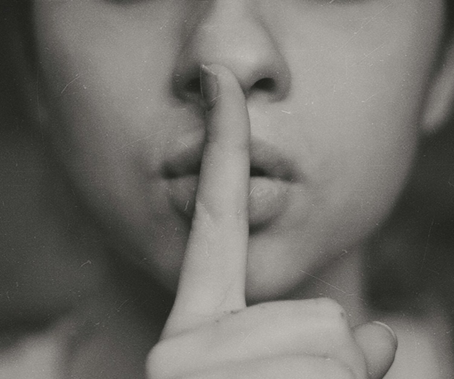 grayscale photo of woman doing silent hand sign
