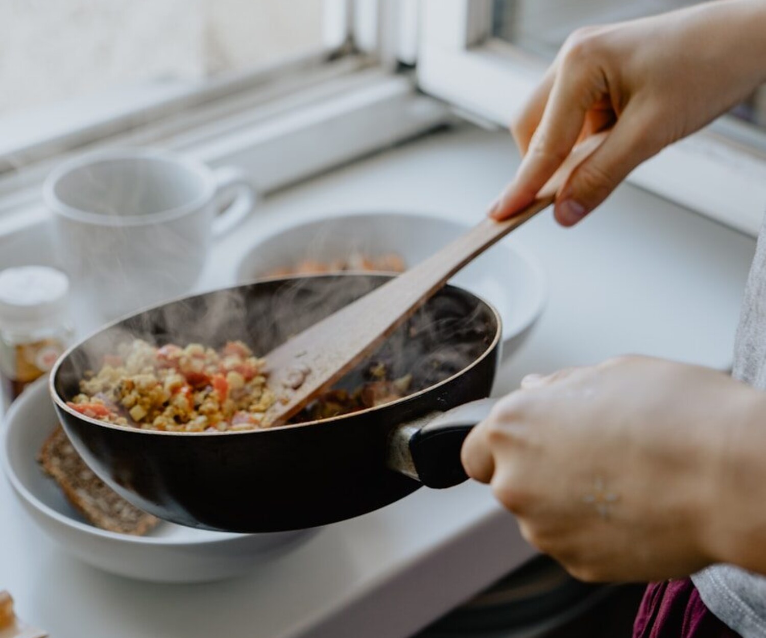 person holding black frying pan