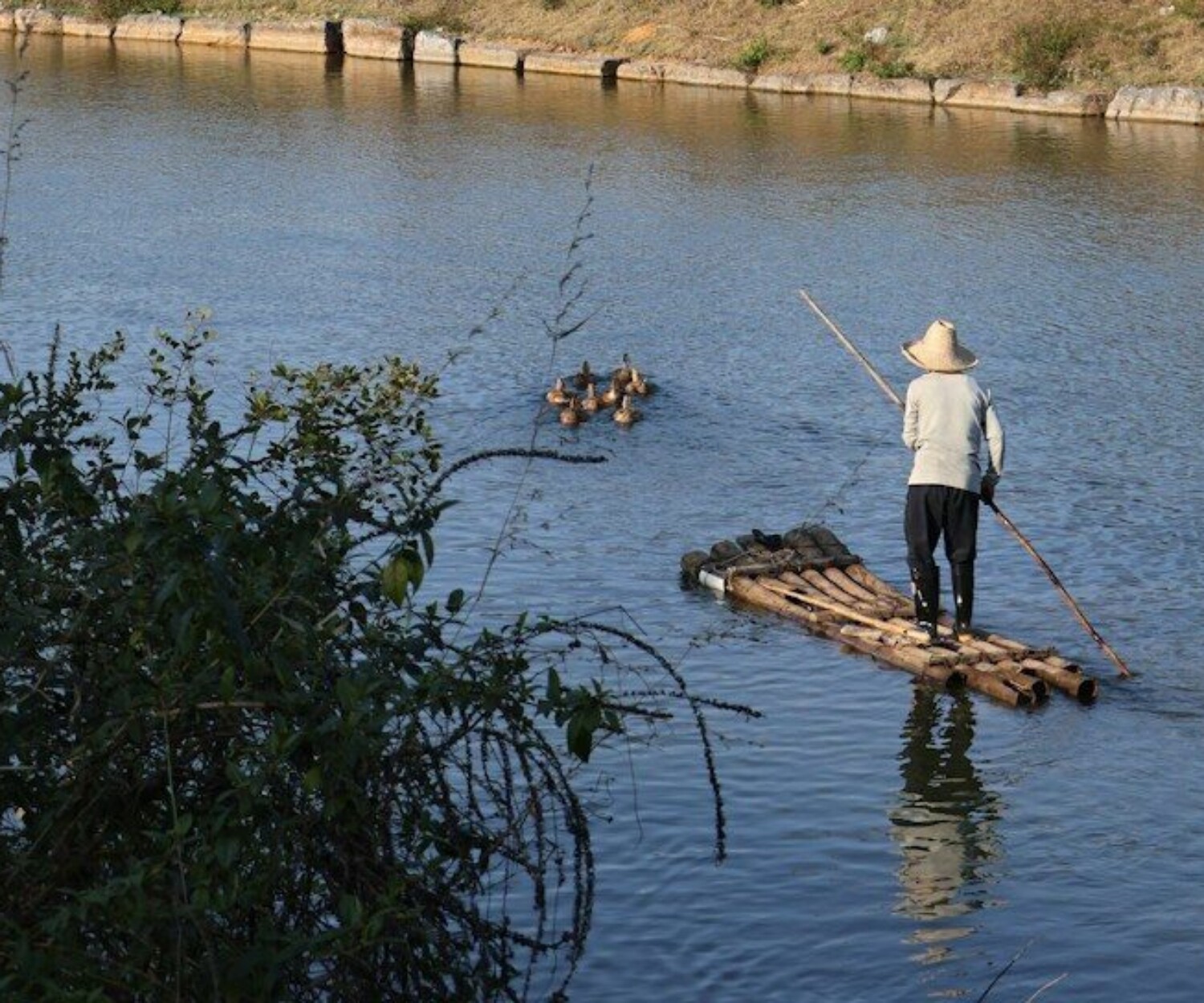 a man standing on a raft in the middle of a river